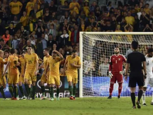 Australian players (L) celebrate their third goal as Jordan goalkeeper Amer Shafi (C) looks on during the World Cup Asian qualifier football match between Australia and Jordan in Sydney on March 29, 2016.
SAEED KHAN / AFP