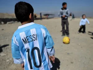 Afghan boy five-year-old Murtaza Ahmadi (C), a young Lionel Messi fan, plays football as he wears a donated and signed shirt by Messi on a field in Kabul on February 26, 2016. Argentine football star Lionel Messi has sent not one, but two jerseys to the five-year-old Afghan boy who became an Internet sensation last month when he was pictured wearing a plastic bag with "Messi" scrawled on it in marker pen. AFP. AFP PHOTO/WAKIL KOHSAR
WAKIL KOHSAR / AFP