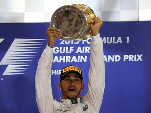 Mercedes AMG Petronas British driver Lewis Hamilton celebrates with his trophy on the podium after winning the Formula One Bahrain Grand Prix at the Sakhir circuit in the desert south of the Bahraini capital, Manama, on April 19, 2015. AFP PHOTO / MARWAN NAAMANI
MARWAN NAAMANI / AFP