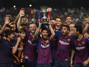 Barcelona's Argentinian forward Lionel Messi (C) carries the cup as they celebrate at the end of the Spanish Super Cup final between Sevilla FC and FC Barcelona at Ibn Batouta Stadium in the Moroccan city of Tangiers on August 12, 2018.
FADEL SENNA / AFP