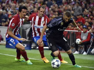 Real Madrid's French forward Karim Benzema (R) vies with Atletico Madrid's Uruguayan defender Diego Godin (C) and Atletico Madrid's Montenegrin defender Stefan Savic during the UEFA Champions League semifinal second leg football match Club Atletico de Madrid vs Real Madrid CF at the Vicente Calderon stadium in Madrid, on May 10, 2017.
GERARD JULIEN / AFP
