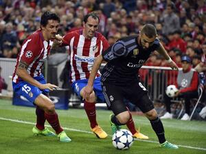 Real Madrid's French forward Karim Benzema (R) vies with Atletico Madrid's Uruguayan defender Diego Godin (C) and Atletico Madrid's Montenegrin defender Stefan Savic during the UEFA Champions League semifinal second leg football match Club Atletico de Madrid vs Real Madrid CF at the Vicente Calderon stadium in Madrid, on May 10, 2017.
GERARD JULIEN / AFP