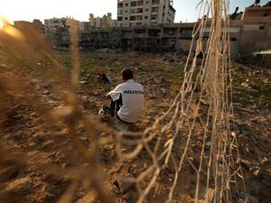 Palestinian runner and football player Bilal Abu Samaan, 20, sits in the rubble of the bombed Palestine Stadium in Gaza City on November 28, 2012. The stadium was bombed by the Israeli airforce during a conflict between the ruling Hamas party and the Israeli military between 14 and 21 November 2012. AFP PHOTO / PATRICK BAZ
PATRICK BAZ / AFP