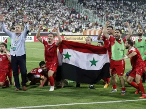 Syria's players celebrate at the end of their FIFA World Cup 2018 qualification football match against Iran at the Azadi Stadium in Tehran on September 5, 2017.
ATTA KENARE / AFP