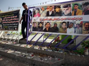 An Iraqi man walks past a poster bearing the portraits of the victims at a cafe, that was popular with local fans of Spain's Real Madrid football club, in the Balad area, north of the capital Baghdad, on May 14, 2016, a day after a deadly raid claimed by Islamic State group militants. At least 16 people were killed and 30 wounded, including several members of the security forces, in the attack in the town of Balad and the ensuing chase, officials said.
AHMAD AL-RUBAYE / AFP