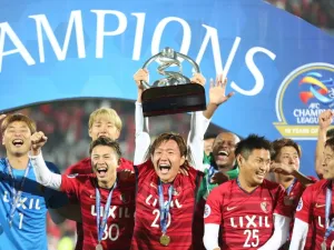 Kashima Antler's midfielder Kento Misao holds the trophy as he celebrates with his teammates after winning the AFC Champions League final football match between Iran's Persepolis and Japan's Kashima Antlers on November 10, 2018, at the Azadi Stadium in Tehran.
ATTA KENARE / AFP