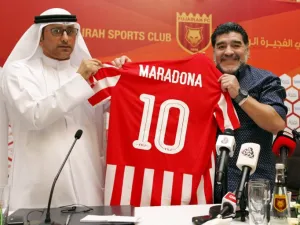 Former Argentinian footballer and manager Diego Armando Maradona (R) holds a jersey of the football club Fujairah FC, bearing his name on the reverse, during a press conference where he was announced as the upcoming manager for the team, in the Gulf emirate of Fujairah on May 14, 2017.
STRINGER / AFP