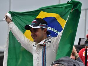 Williams Martini Racing's Brazilian driver Felipe Massa, holding his country's flag, greets fans after his final appearance at Interlagos circuit before retirement, at the end of the Brazilian Grand Prix in Sao Paulo, Brazil, on November 13, 2016.
Nelson Almeida / AFP