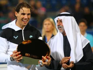 Spanish player Rafael Nadal (L) poses with his winning trophy next to UAE Sports and Youth Minister Sheikh Nahyan Bin Mubarak al-Nahyan after beating Canadian player Milos Raonic in the final match of the Mubadala World Tennis Championship in Abu Dhabi on January 2, 2016. AFP PHOTO / MARWAN NAAMANI
MARWAN NAAMANI / AFP