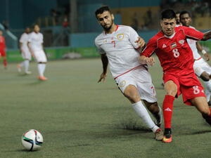 Palestine, in red, vs. Oman at Faisal Husseini Stadium near Jerusalem. Palestine won 2-1. (Photo: Palestinian Football Association)