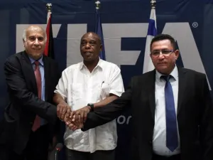(From L-R) Palestinian Football Association president Jibril Rajoub, Chairman of the FIFA Monitoring Committee Israel-Palestine Tokyo Sexwale and Israel's Football Association president Ofer Eini, shake hands at the end of a press conference in the West Bank city of Jericho, following a meeting on December 16, 2015. AFP PHOTO /
THOMAS COEX / AFP