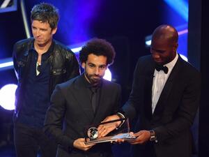 British singer-songwriter Noel Gallagher (L) and former Ivory Coast player Didier Drogba present Liverpool and Egypt forward Mohamed Salah (C) with the trophy for the FIFA Puskas Award for 2018, the best goal scored between July 2017 and July 2018 during The Best FIFA Football Awards ceremony, on September 24, 2018 in London.
Ben STANSALL / AFP