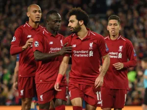 Liverpool's Egyptian midfielder Mohamed Salah (2nd R) celebrates with Liverpool's Senegalese striker Sadio Mane (2nd L) and Liverpool's Brazilian midfielder Fabinho (L) after scoring their third goal from the penalty spot during the UEFA Champions League group C football match between Liverpool and Red Star Belgrade at Anfield in Liverpool, north west England on October 24, 2018.
Oli SCARFF / AFP