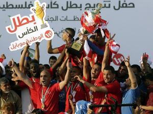 Players of Shabab Rafah football club celebrate their team's victory in the 2017 edition of the Gaza Cup at Yarmouk Stadium in Gaza City on May 12, 2017.
MAHMUD HAMS / AFP
