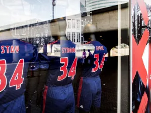 A picture taken through a shop window show football jerseys bearing the words 'Stay Strong Appie' and the number 34 to show support to Ajax midfielder Abdelhak Nouri at the Ajax football club store in Amsterdam on July 10, 2017. Koen van Weel / ANP / AFP