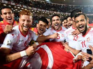 Players of the Tunisian national football team celebrate with their national flag after qualifying for the 2018 World Cup finals after drawing their qualifiers match against Libya at the Rades Olympic Stadium in the capital Tunis on November 11, 2017.
FETHI BELAID / AFP