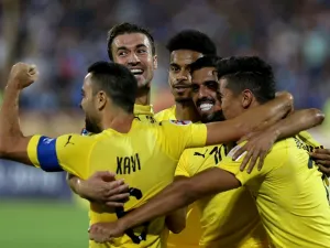 Al-Sadd's forward Baghdad Bounedjah (1st-R) celebrates after scoring a goal with his teammates, Spanish midfielders Xavi Hernandez (1st-L) and Gabi (2nd-L) during the AFC Champions League football match Al-Sadd (Qatar) vs Esteghlal FC (Iran) at the Azadi stadium in Tehran on August 27, 2018.
ATTA KENARE / AFP