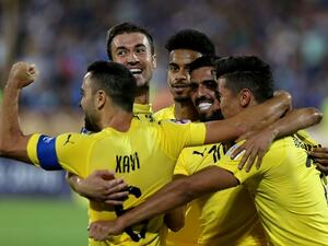 Al-Sadd's forward Baghdad Bounedjah (1st-R) celebrates after scoring a goal with his teammates, Spanish midfielders Xavi Hernandez (1st-L) and Gabi (2nd-L) during the AFC Champions League football match Al-Sadd (Qatar) vs Esteghlal FC (Iran) at the Azadi stadium in Tehran on August 27, 2018.
ATTA KENARE / AFP