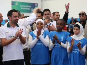 Former Barcelona football player Xavi Hernandez (L), who currently plays for Al-Sadd in the Qatar Stars League, claps as he attends a training session during his visit to the al-Baqaa Palestinian refugee camp near Amman on September 29, 2016.
Khalil MAZRAAWI / AFP