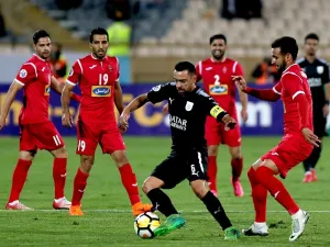Al-Sadd's Xavier Hernandez (C) dribbles the ball as Persepolis' Ahmad Noorollahi (R) defends during the AFC Champions League match between al-Sadd and Persepolis at the Azadi Stadium in Tehran on April 16, 2018.
ATTA KENARE / AFP