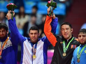 Gold medalist Iran's Reza Yazdani (2nd L) poses with silver medalist Kyrgyzstan's Magomed Musaev (L) and bronze medalists Mongolia's Khuderbulga Dorjkhand (2nd R) and Kazakhstan's Mamed Ibragimov (R) in the medal ceremony of the men's freestyle 97 kg wrestling event during the 2014 Asian Games at the Dowon Gymnasium in Incheon on September 28, 2014. AFP PHOTO / JUNG YEON-JE
JUNG YEON-JE / AFP