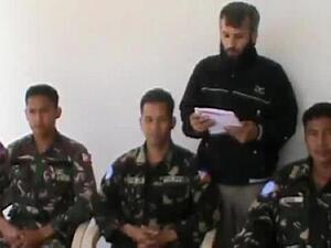 An image grab taken from a video uploaded on YouTube on May 08, 2013 reportedly shows a man reading a statement at an undisclosed location in Syria, behind four abducted Filipino UN peacekeepers. (AFP/ YouTube)