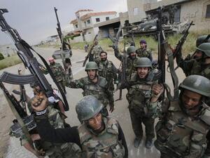 Syrian troops celebrate as they take control of the village of Haydariyah, some seven kilometers outside the rebel-held city of Qusayr (AFP/ Joseph Eid)