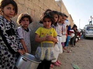 SYRIA, RAQQA : Syrian children wait in line to collect a free “Iftar” meal in the northern city of Raqqa during the Muslim holy month of Ramadan on July 14, 2013. (AFP PHOTO/MEZAR MATAR) 