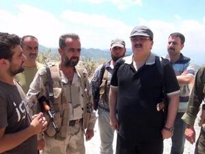 SYRIA, Latakia : An image grab taken from a video published on the Youtube account Jableh1990 on August 11, 2013 allegedly shows Syrian rebel leader General Salim Idris (C-R) talking to rebel fighters in the outskirts of Latakia.  AFP PHOTO/YOUTUBE