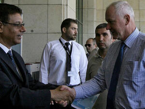 SYRIA, DAMASCUS : A UN Syrian staff (L) welcomes Swedish scientist Ake Sellstrom (R) and Angela Kane (unseen), the UN high representative for disarmamen, at a hotel in Damascus on July, 24, 2013. The two senior UN inspectors tasked with examining claims that chemical weapons have been deployed in Syria's civil war arrived in Damascus today. AFP PHOTO/LOUAI BESHARA