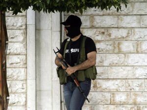 A masked gunman opposed to the Shiite party Hezbollah, stands in the southern town of Sidon's eastern suburb of Abra, on June 18, 2013. (File photo / AFP)
