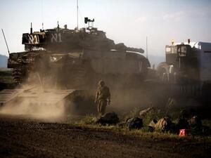 An Israeli Merkava tank is positioned for deployment during a drill in the Israeli annexed Golan Heights near the border with Syria on May 5, 2013. (Menahem Kahana/AFP)