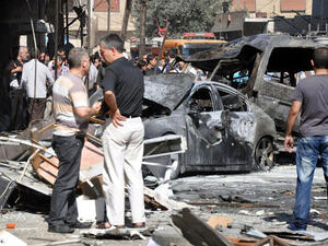 SYRIA, DAMASCUS : A handout picture released by the Syrian Arab News Agency (SANA) shows Syrians looking at burned-out car bombs after an attack that at least killed seven people and wounded 62 on July 25, 2013 in Jaramana suburb in southeast Damascus. AFP PHOTO / HO / SANA 