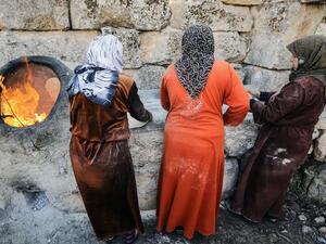 نساء سوريات يخبزن على الطابون في بلدة معرة النعمان قرب حلب/شمال/أ.ف.ب