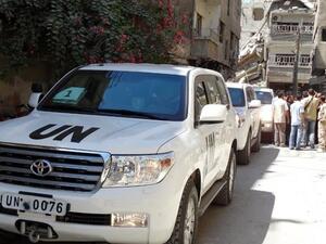 SYRIA, DAMASCUS : Syrians gather near vehicles of the United Nations (UN) arms experts as they inspect a site suspected of being hit by a deadly chemical weapons attack last week on August 28, 2013 in the Eastern Ghouta area on the northeastern outskirts of Damascus. AFP PHOTO /MOHAMED ABDULLAH