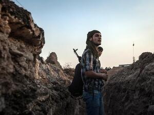 SYRIA, DERIK : Fighters of the Kurdish of the Committees for the Protection of the Kurdish People (YPG) stand in a trench on August 28, 2013 about 30 kms south of the Kurdish town of Derik (aka al-Malikiyah in Arabic), in northeastern Hasakeh governorate, on the border with Turkey and Iraq. AFP PHOTO ALICE MARTINS