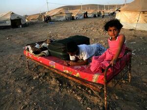 IRAQ, Arbil : A Syrian-Kurdish children sitting on a bed at the Quru Gusik refugee camp, 20 kilometres east of the of Arbil, the capital of the autonomous Kurdish region of northern Iraq, on August 22, 2013. TOPSHOTS/AFP PHOTO/SAFIN HAMED