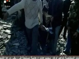 شخاص يحملون جثة احد ضحايا تفجيري دمشق يوم الجمعة. 