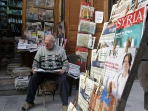 سوري يطالع الصحف امام محله في دمشق
