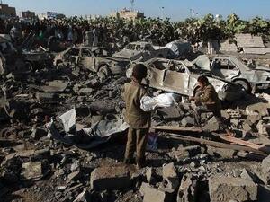 Civilians survey the damage from a Saudi-led coalition airstrike near Sanaa airport in Yemen. (AFP/File)