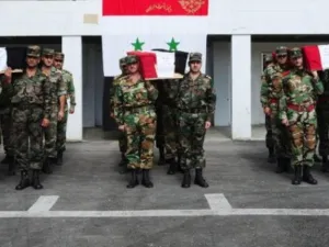 جنود سوريون يشيعون جثامين زملاء لهم قتلوا خلال العمليات العسكرية