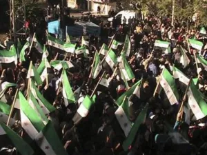 متظاهرون ضد الرئيس السوري بشار الاسد يلوحون بالاعلام السورية القديمة خلال مسيرة بالقرب من درعا يوم الاحد. 