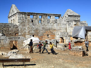 Syrian refugee children play in front of the ruins of the public baths of the ancient Byzantine-Christian city of Serjilla. (Image credit: AFP)