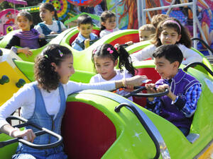Syrian children ride on a merry-go-round as families celebrate the Muslim feast of Eid al-Adha. (Image credit: AFP)