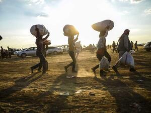 Displaced Syrian Kurds haul their personal belongings across the Syrian-Turkish border, September 2014.  (AFP/Bulent Kilic)