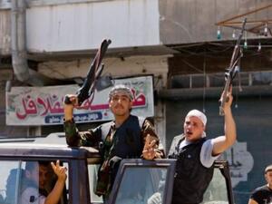 Syrian rebels hold their weapons aloft