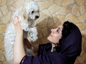An Iranian woman plays with her pet terrier.  (AFP/Behrouz Mehria)