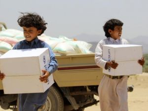 Children carry supplies handed out by UNICEF outside the Yemeni capital Sanaa.  Heavy airstrikes and ground fighting across the country have made it extremely difficult for humanitarian aid to reach Yemen's civilians.  (AFP/File)