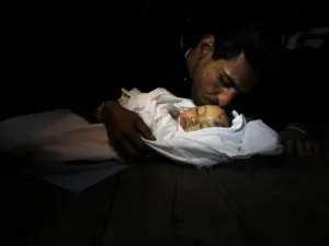 والد الطفلة التي ذهبت ضحية القصف الاسرائيلي على الزيتون بغزة،حنين طافش، 10 اشهر، يقبل جبينها قبل ان توارى في الثرى/أ.ف.ب