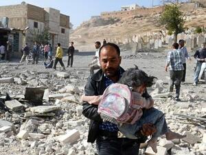 سوري يسعف طفلة اصيبت بقصف جوي في منطقة الباب شمال سوريا/أ.ف.ب